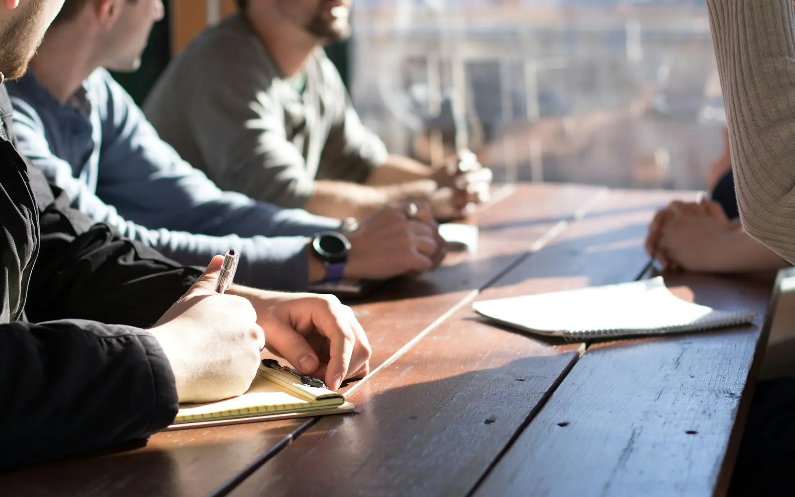 Professionals taking notes in a hiring discussion