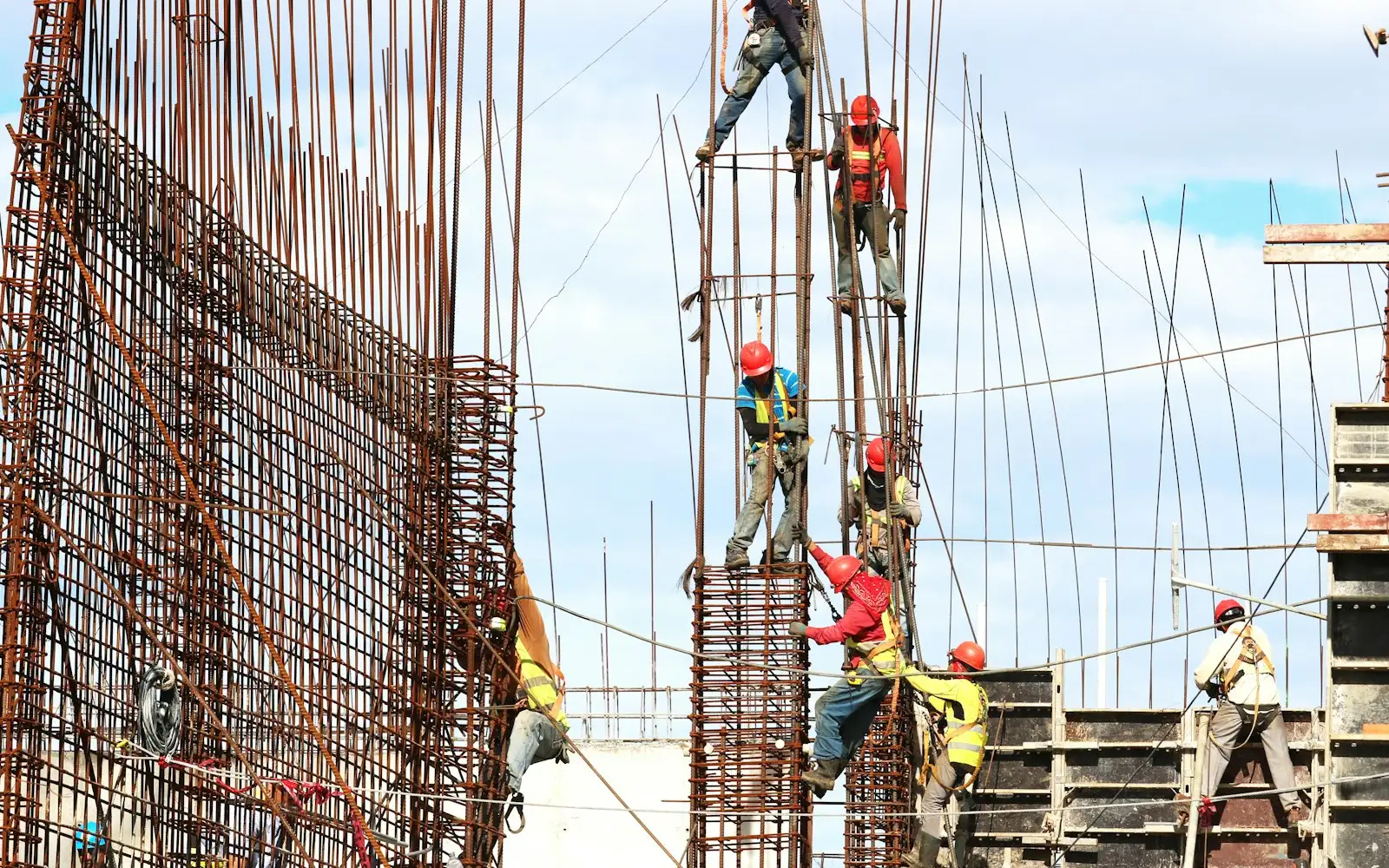 Ironworkers climbing rebar on a high-rise deck