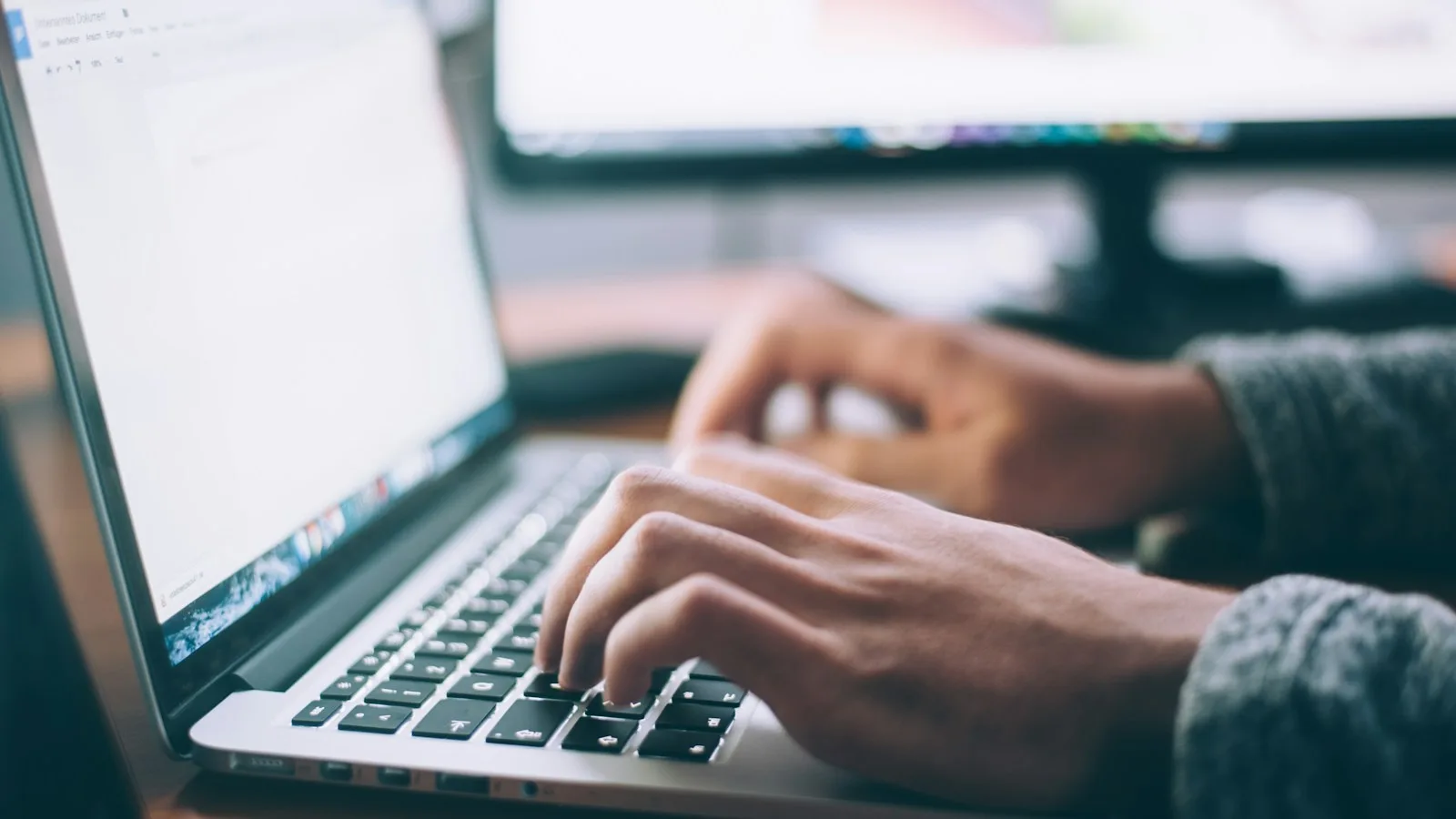 Hands typing a job search on a laptop