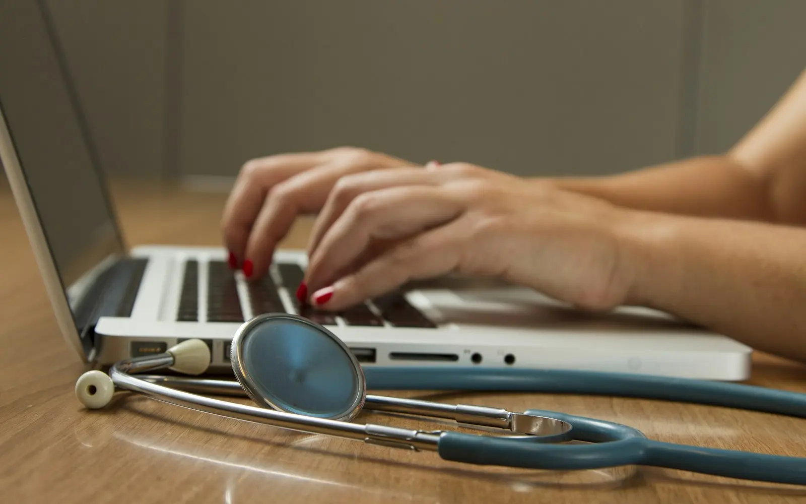 Healthcare operations work at a laptop beside a stethoscope