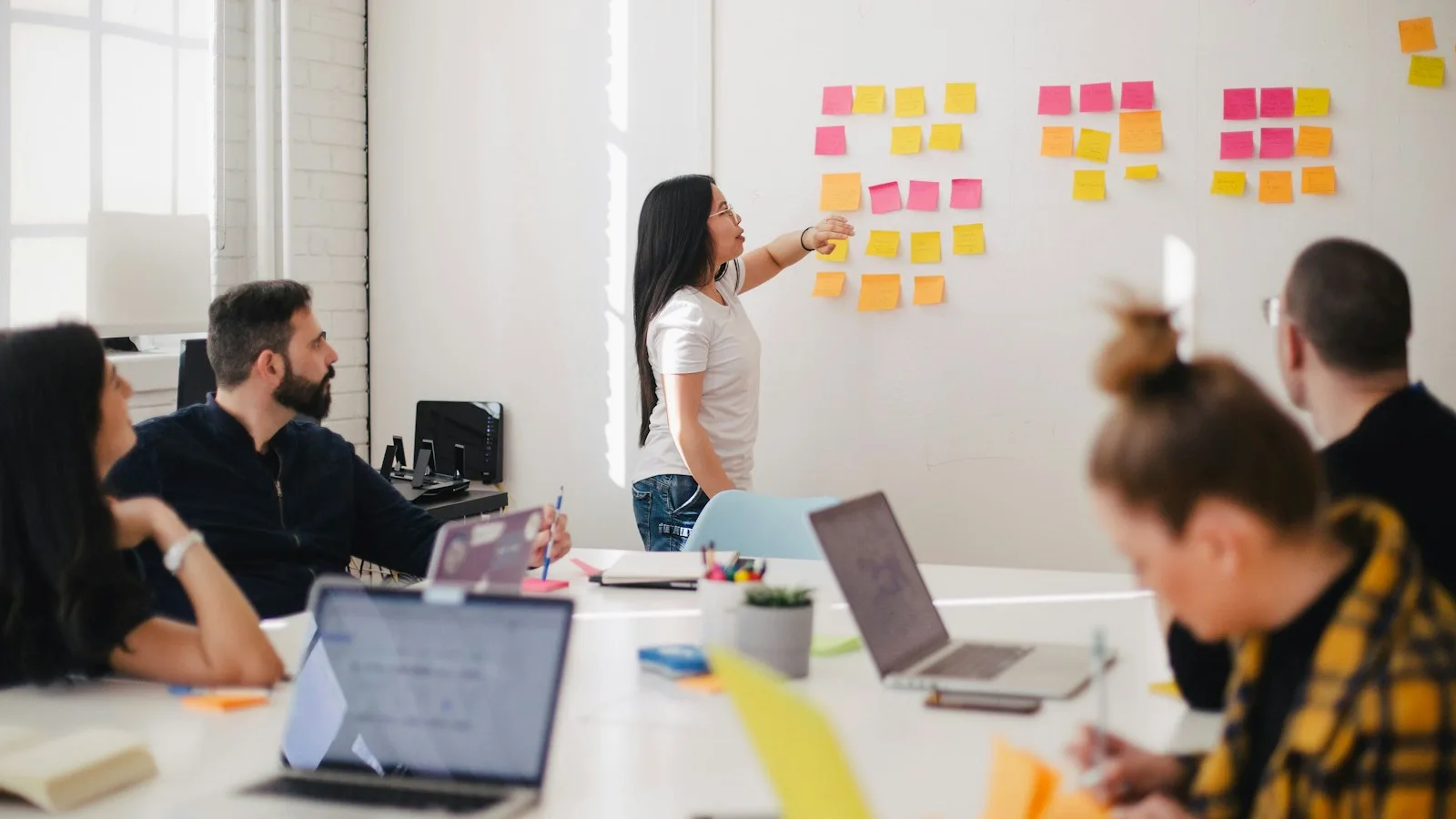 Team mapping a hiring plan on a wall of sticky notes