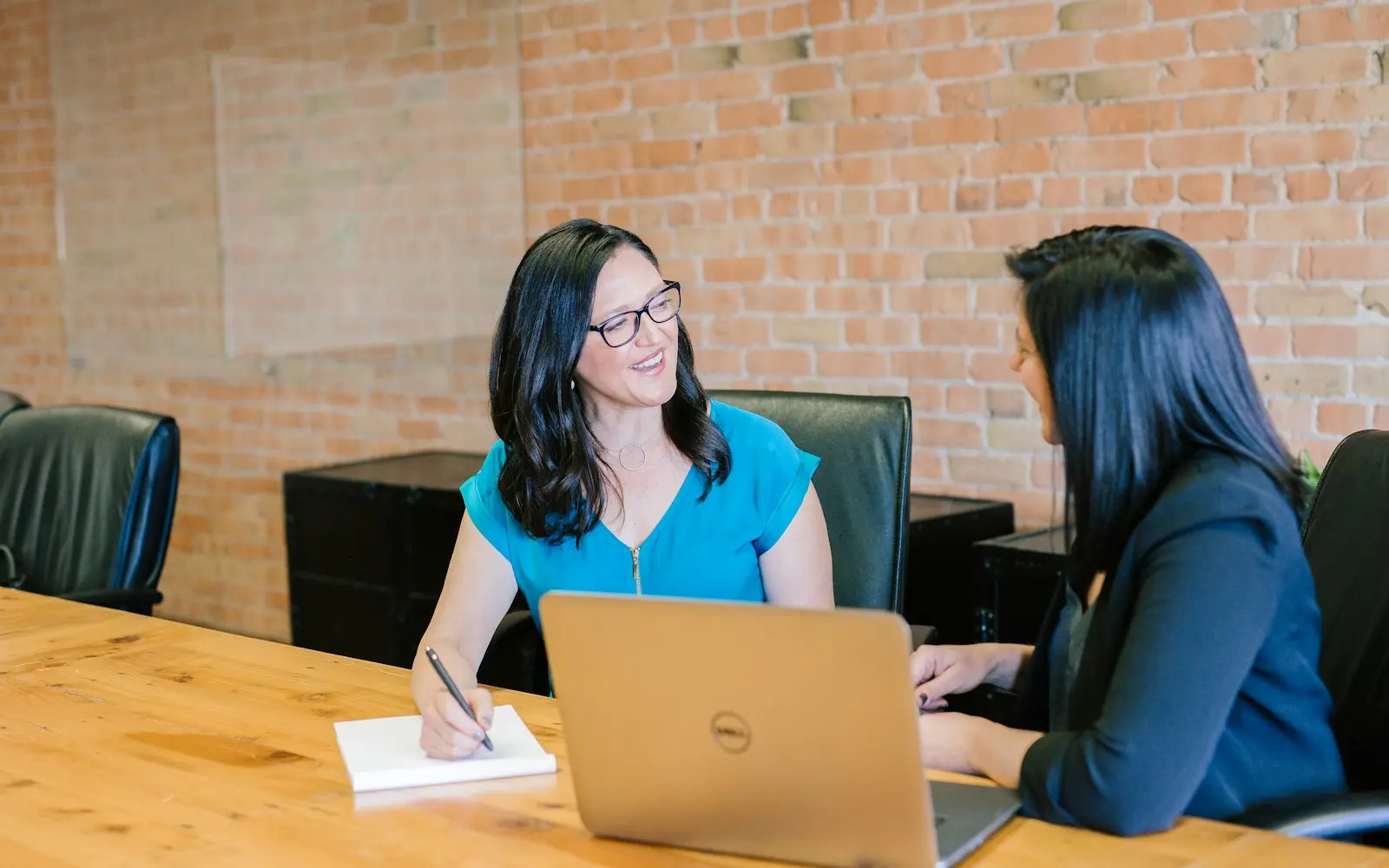 Recruiter and candidate reviewing notes beside a laptop